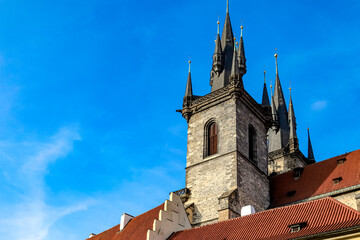 Fototapeta premium A tall building Temple of the Mother of God in front of the Tyn with a red roof and a blue sky in the background in Prague Czech Republic