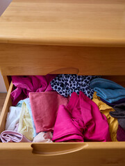 The linen from the drawer is crumpled and lies in a pile. Clutter and problems of space organization.