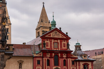 St. George's Basilica rising above Prague roofs on cloudy day