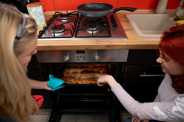 Cooking Together Friends Engaging in a Delightful Baking Experience in a Modern Kitchen