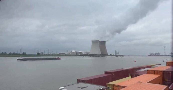 An inland vessel passes the cooling towers of the Doel nuclear power plant 