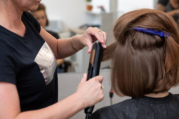 Naklejka premium Professional Hair Salon Styling Using Expert Flat Iron Techniques for Striking Looks