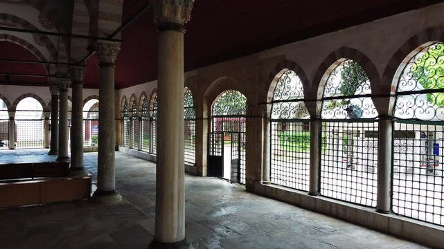 The courtyard of the Valide-i Atik Mosque, one of the important examples of Ottoman classical architecture, with the portico and iron railings in the courtyard. The camera moving towards the door.