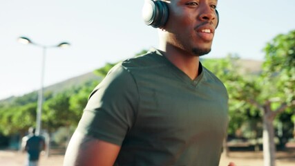 Headphones, running and black man in park for training, wellness and fitness. Radio, podcast and African athlete with endurance exercise, challenge and workout for cardio and jog outdoors in nature