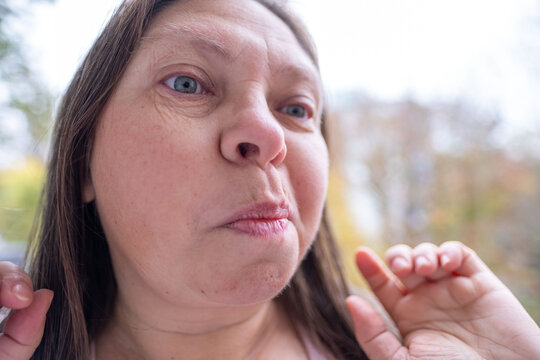 skeptical woman narrows eyes, expression filled with doubt in natural setting, raised eyebrow and tight lips convey skepticism in intimate nature portrait, unexpected doubts, mistrust