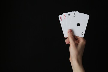 Woman with playing cards against black background, closeup. Space for text