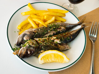 Tradishional spanish seafood Jurel a la plancha, grilled mackerel with lemon and fries
