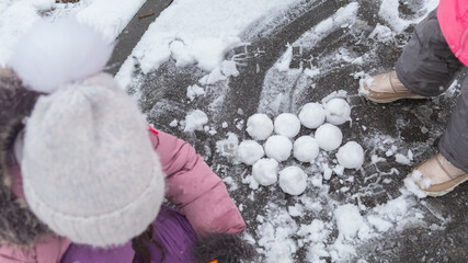 Active recreation with children in winter on cold days. Happy siblings having fun with snow
