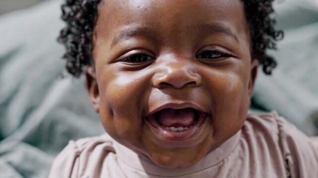 Smiling baby with visible dimples in joyful moment. Great for baby products, health campaigns, or cheerful advertising visuals.
