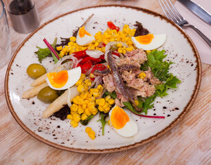 Popular dish of Spanish cuisine is the Xato salad, made from escalora, chopped salted cod, anchovies, olives, corn, onions, ..boiled eggs, red pepper and lettuce leaves