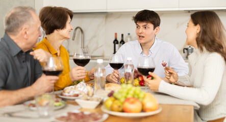Happy family having dinner together at the festive table at home