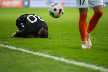 The injured footballer lies on the pitch.