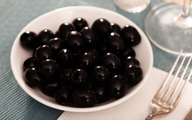 White plate with delicious pitted black olives