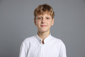 Portrait of teenage boy on grey background
