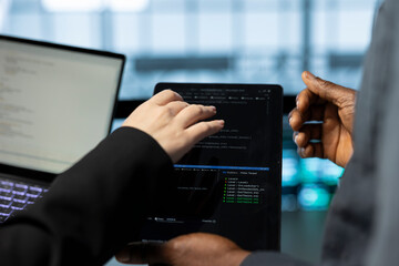 Engineers in data center using laptop and tablet, employing machine learning models. Close up of employees using devices to fulfill infrastructure needs, allocating resources efficiently