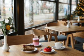 Aromatic coffee and delicious desserts served on wooden table in cafe