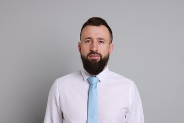 Handsome bearded man in formal outfit on grey background