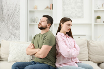 Obraz premium Resentful couple with crossed arms sitting on couch at home