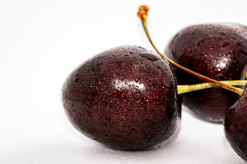 Black Cherries, on white and wooden backgrounds