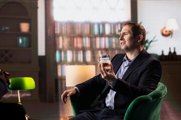 Old money classy heir drinking a glass of whiskey at elite social club, thinking about an opportunity to double his fortune. Elegant upper class billionaire gentleman sipping alcohol.