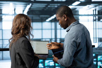 Programmers in data center facility workplace use laptop to calibrate supercomputers energy usage....