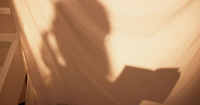 Home, girl and reading book in tent, night and calm with hobby, development and literature. Apartment, childhood and kid in living room, learning and shadow with story, growth and silhouette