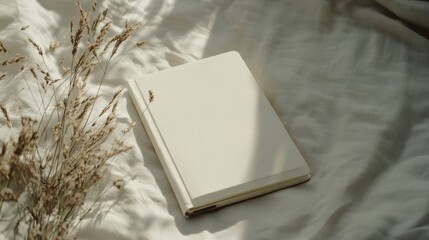 Fototapeta premium Offwhite Notebook and Dried Flowers on Beige Fabric