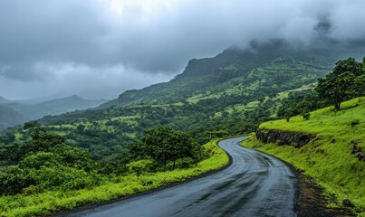 Naklejka premium Winding road through lush green hills under cloudy sky