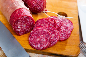 Appetizing traditional spanish salchichon sausage on wooden table