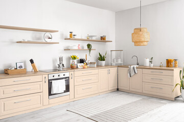 Interior of light kitchen with different utensils, vase with flowers and Easter decor