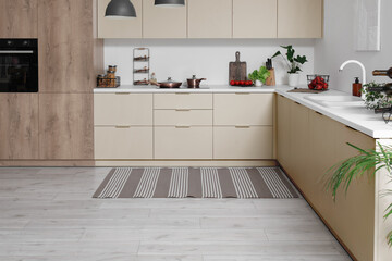Stylish striped rug in interior of modern kitchen