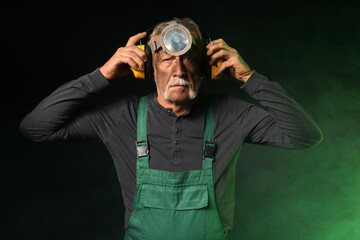 Mature miner man and green smoke on black background