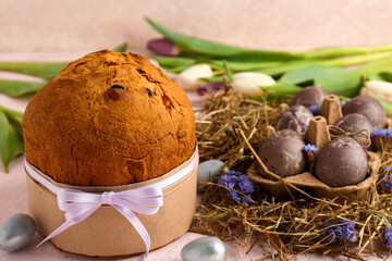 Delicious Easter cake with painted eggs and tulip flowers on beige background