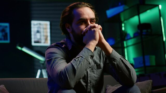 Livid supporter cursing own team for getting defeated during live match broadcast, expressing anger. Mad man throwing pillow in frustration seeing favorite club commit blunder, camera A
