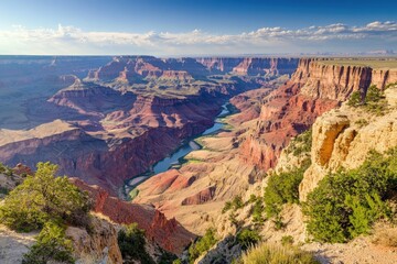 Naklejka premium Grand Canyon vista, high viewpoint, sunlit river, distant clouds