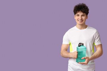 Naklejka premium Sporty guy with bottle of water on lilac background