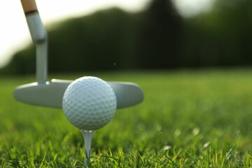 Hitting golf ball with club on green course, closeup. Space for text