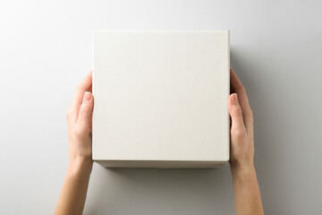 Woman with blank cardboard box on white background, top view. Mockup for design