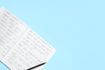 Fototapeta premium Copybook with handwritten maths formulas and pencil on blue background