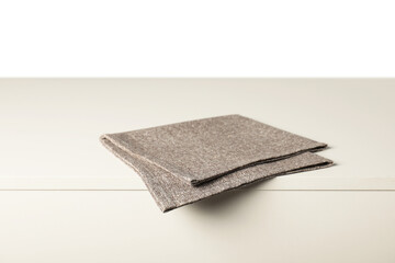 Gray napkin on light table against white background