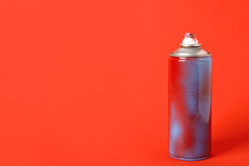 Spray paint can on red background