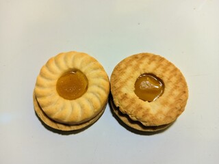 close up view of biscuits with pineapple jam on white background