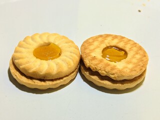close up view of biscuits with pineapple jam on white background