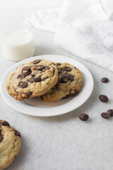 Large chocolate chip cookies on a white countertop, top view of homemade chocolate chip cookies on a white background