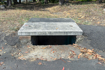 Photograph of an old and weathered concrete water drain located near the edge of a regional road....