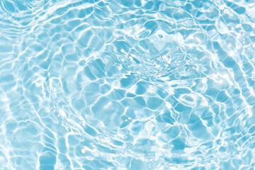 Blue water with ripples on the surface. Defocus blurred transparent blue colored clear calm water surface texture with splashes and bubbles. Water waves with shining pattern texture background.