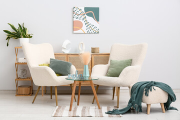 Interior of living room with armchairs, table and pouf