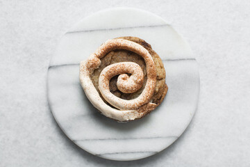 Overhead view of frosting coated cinnamon cookies, top view of cinnamon cookies with a vanilla cream frosting, process of making bakery style cookies