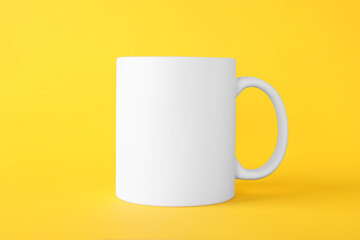 One blank white mug on yellow background. Mockup for design