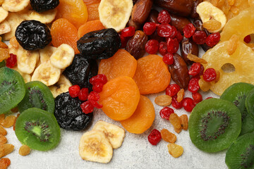 Mix of different dried fruits on grey table, top view